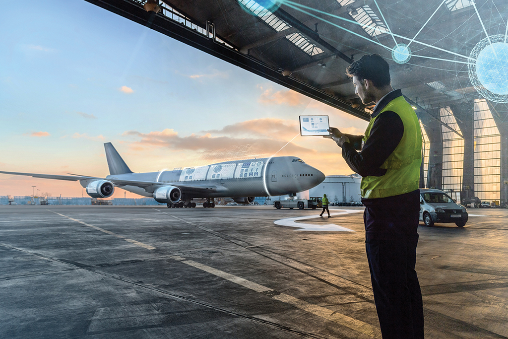 Concept of employee holding up tablet inspecting aircraft from distance