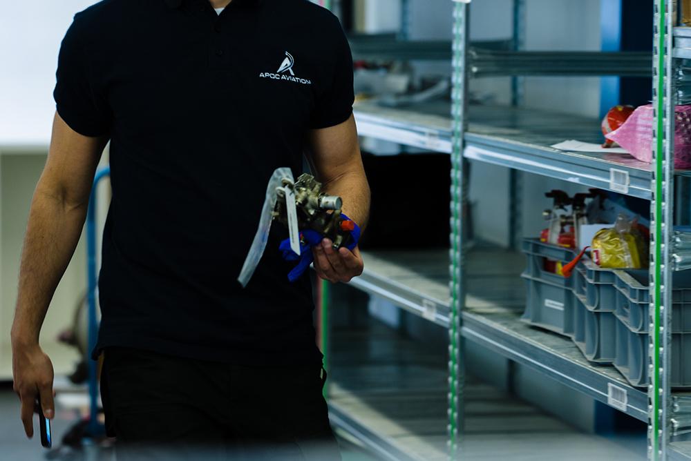 Technician holds a part in a warehouse