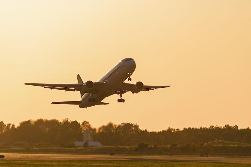 airplane flying into sunset