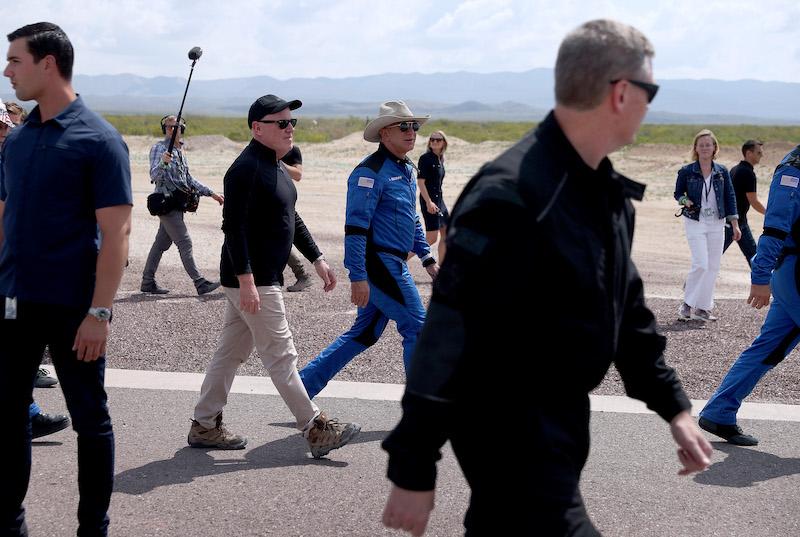 Blue Origin CEO Bob Smith (black hat) walks with Jeff Bezos 