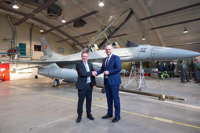 Defense Minister Bjørn Arild Gram congratulates Cristian Bădescu, Romania's ambassador to Norway, in front of one of three F-16s that were handed over at Rygge air station