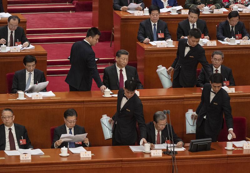 Chinese President Xi Jinping (C) and Premier Li Qiang (R) are served tea by hosts at the opening of the NPC, or National People's Congress, at the Great Hall of the People on March 5, 2024 in Beijing, China