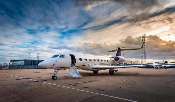 business aircraft on ground at Luton Airport, England, near sunset