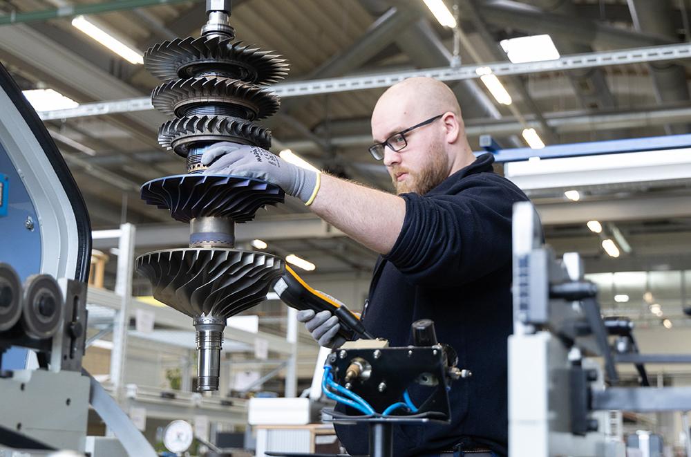 A technician services a Honeywell HGT1700 APU component at Lufthansa Technik.