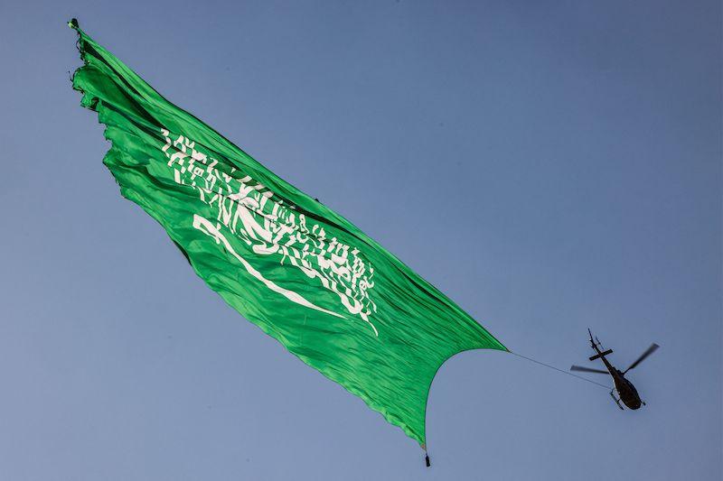 A helicopter flies over with a giant Saudi flag during an air show marking Saudi Arabia's 93rd National Day celebrations in Riyadh 