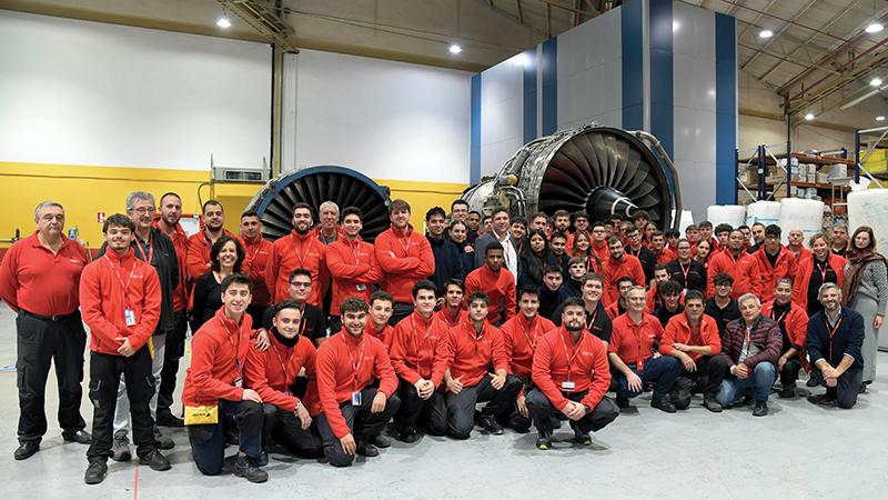 Group of students posing by two engines