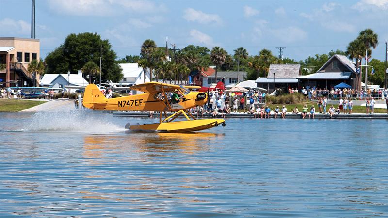 A yellow seaplane rides the water