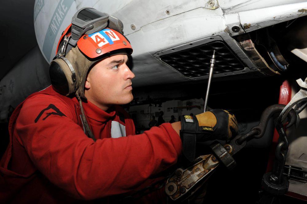 Credit: U.S. Navy. Caption: U.S. Marine removed flare and chaff magazine from an F/A-18 on the USS Nimitz.