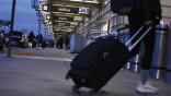 Person pulling luggage entering airport