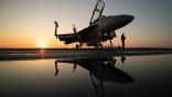 Boeing EA-18G chained to flight deck with sunset in background